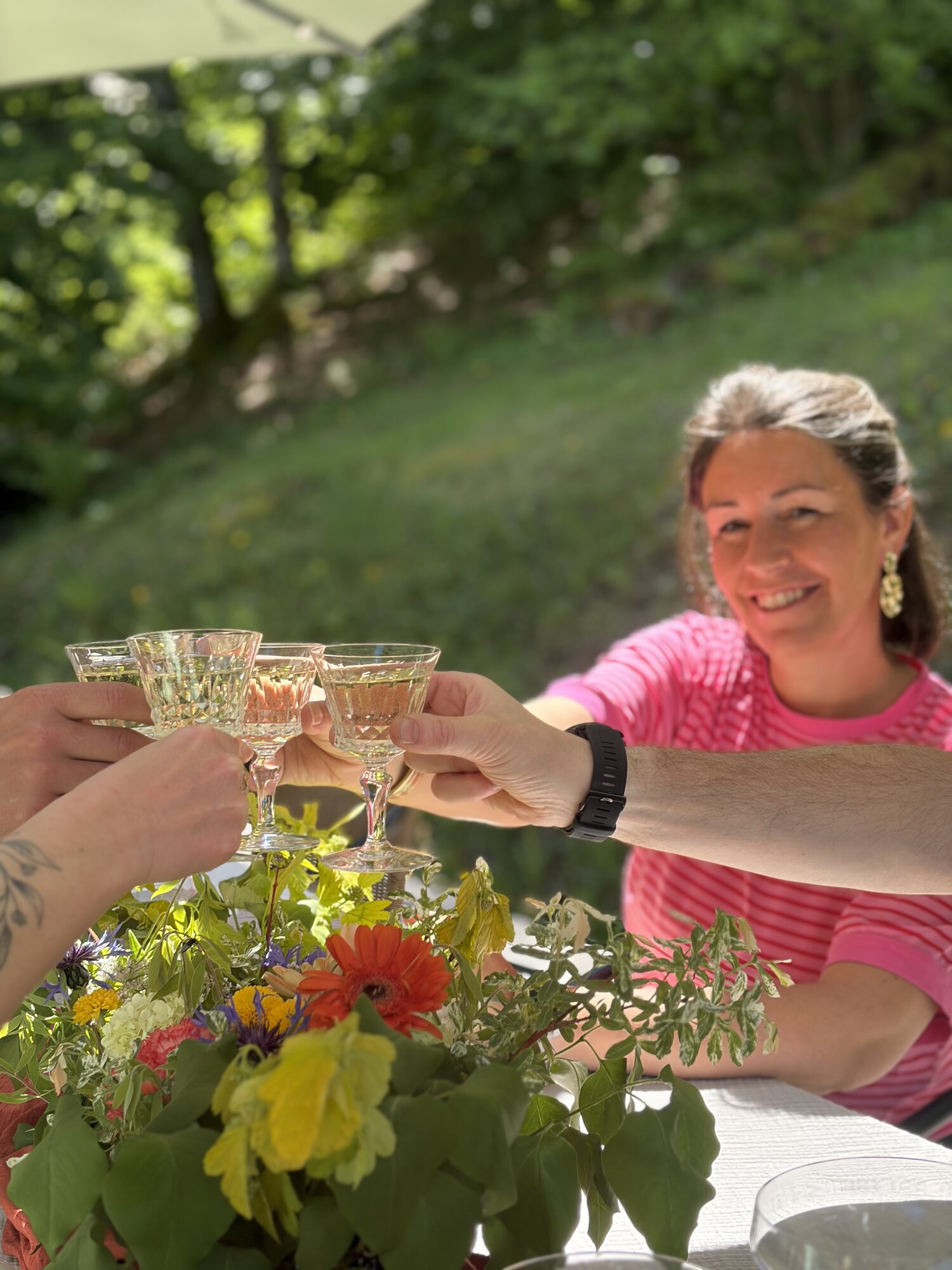 Trinquage de coupes en terrasse autour d'un bouquet sauvage